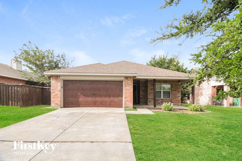 a brick house with a driveway and a garage door