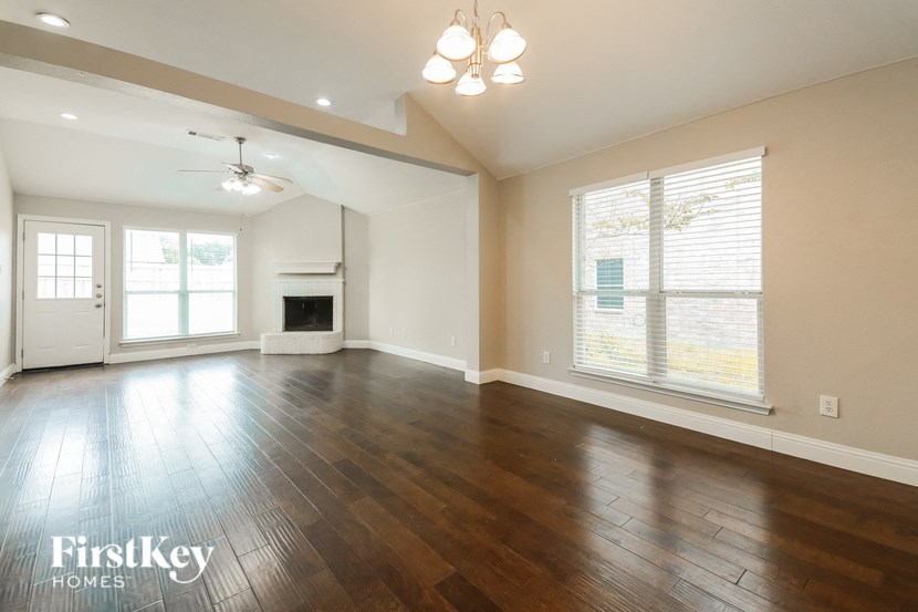 an empty living room with wood floors and a fireplace