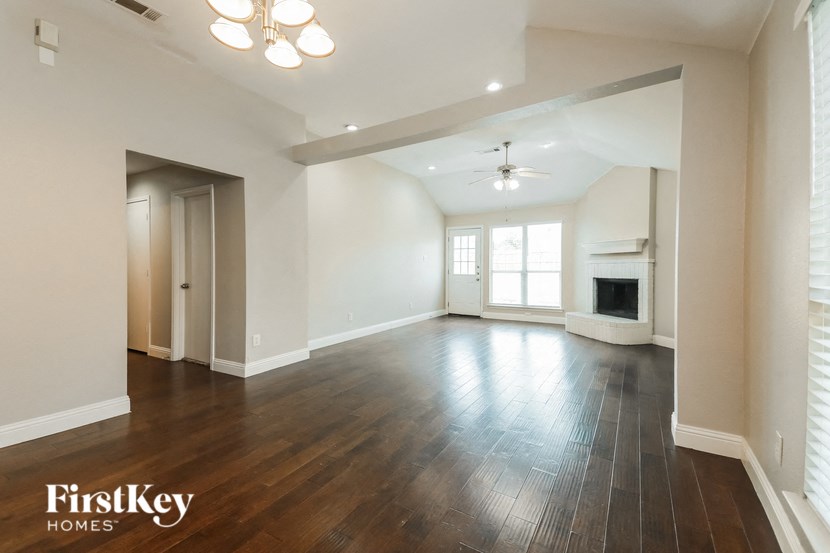an empty living room with hardwood floors and a fireplace
