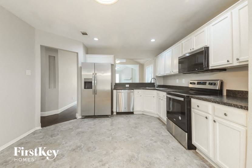 a kitchen with white cabinets and stainless steel appliances