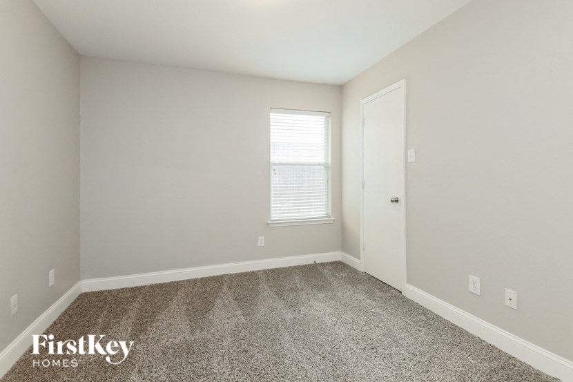 a bedroom with a carpeted floor and a window