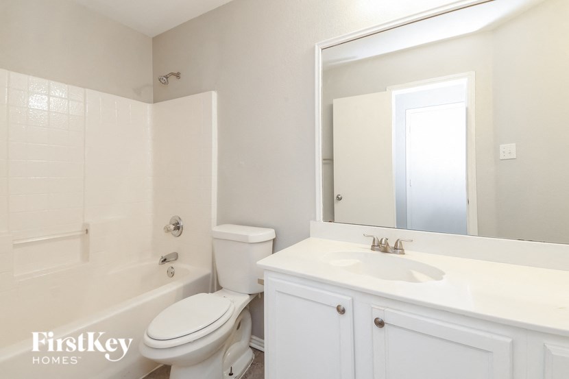 a bathroom with a sink toilet and a mirror