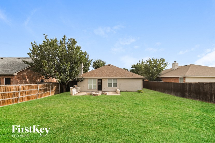 a backyard with a house and a fence