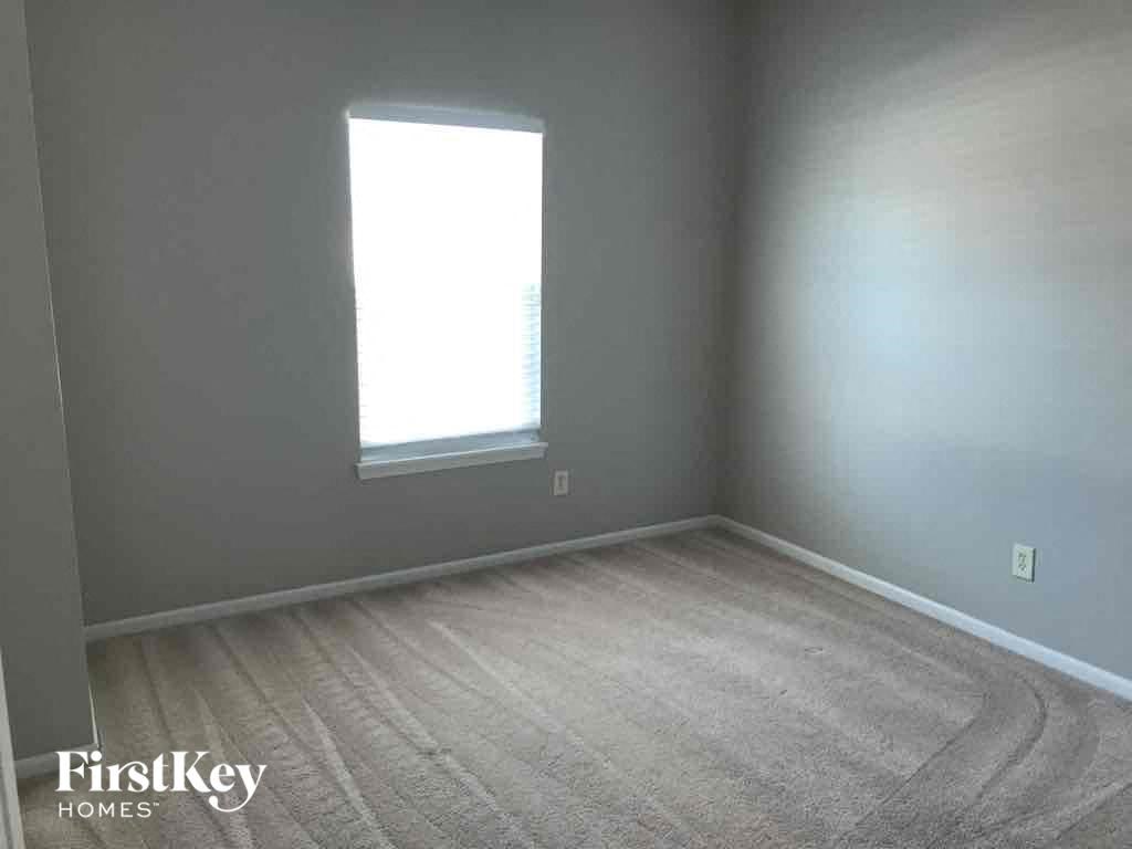 A room with a window and carpeted floor.