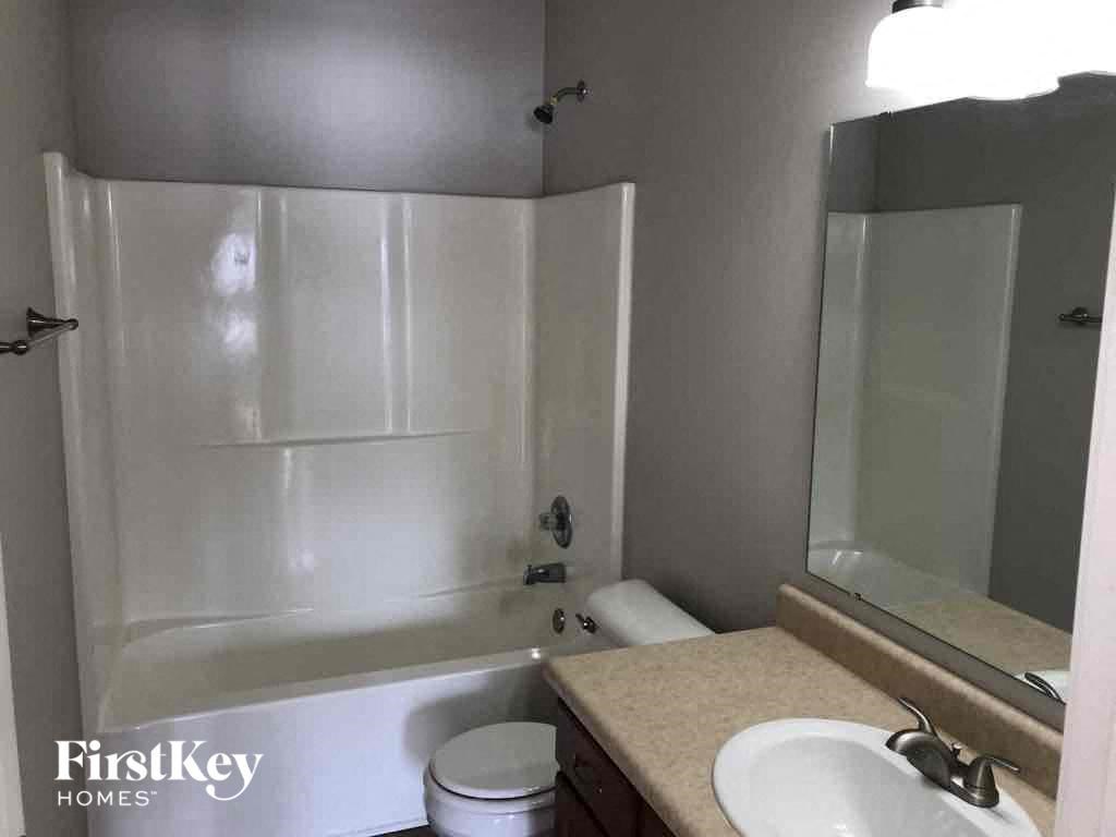 A white toilet sits next to a sink in a bathroom.