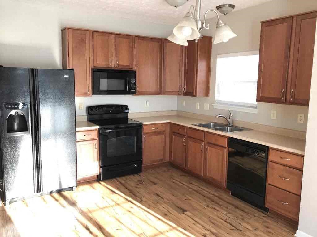 A kitchen with wooden cabinets and black appliances.