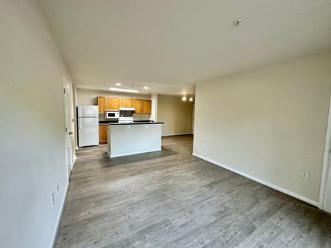 A kitchen with a white fridge and microwave with a countertop and a dining table.