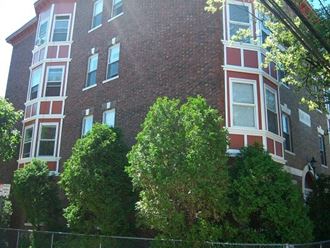 a brick building with trees in front of it