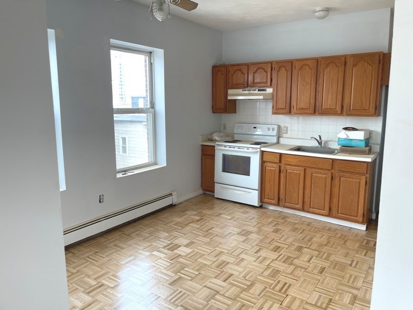an empty kitchen with wooden floors and wooden cabinets