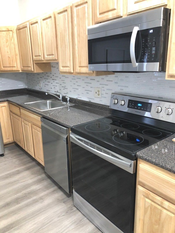 a kitchen with a stove microwave and a sink