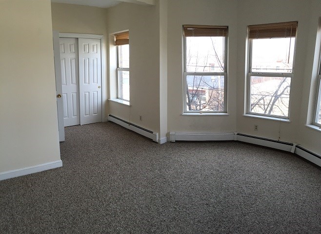 an empty room with three windows and a door
