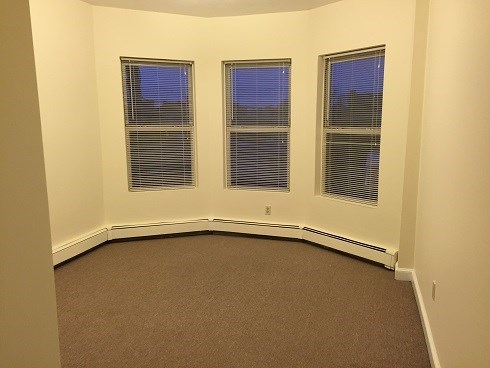 an empty room with three windows