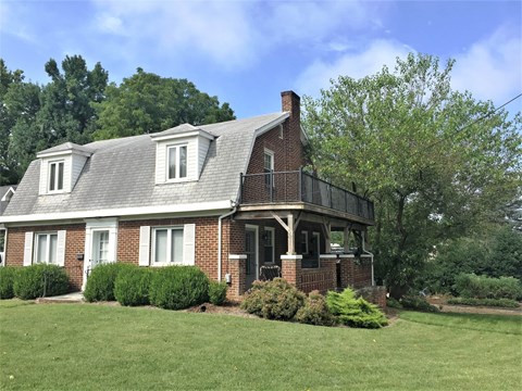 A house with a brick facade and a grey roof.