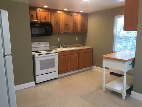 A kitchen with a white stove and a white refrigerator.