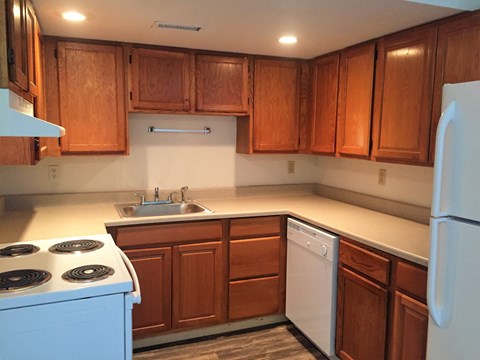 A kitchen with wooden cabinets and a white refrigerator.