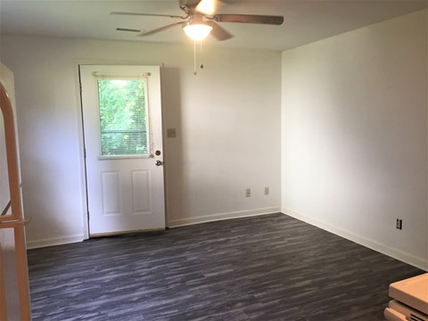 A room with a ceiling fan and a door with a window.