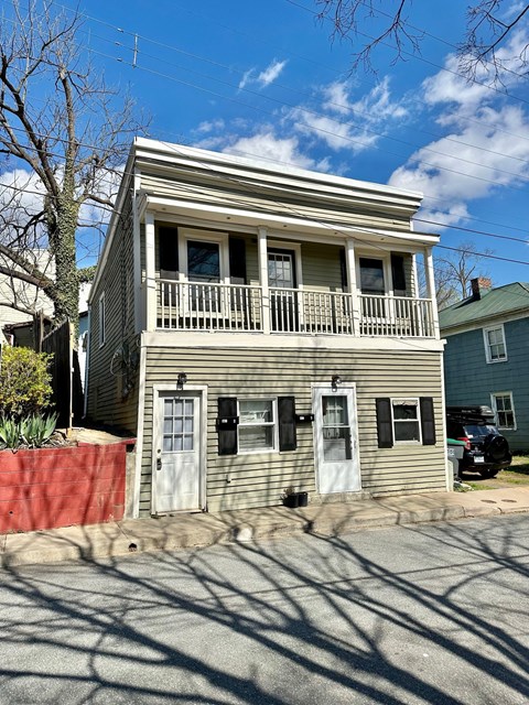 A two-story house with a balcony on the second floor.