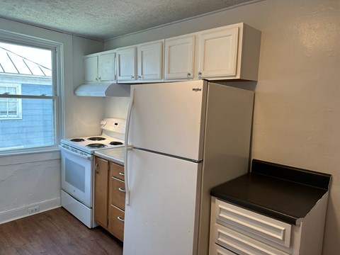A kitchen with a white refrigerator and a white stove.
