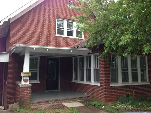 a red brick house with white windows and a porch