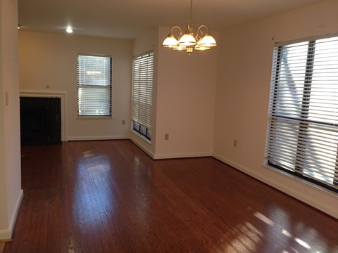 an empty living room with wood floors and windows