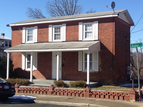 a red brick house with a street sign in front of it