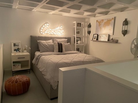 A bedroom with a bed, nightstand, and a lamp.