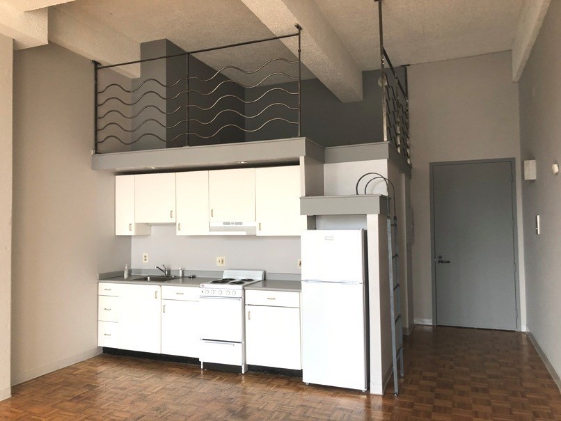 an empty kitchen with white cabinets and a sink