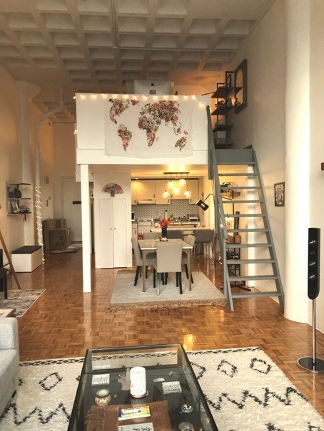 a living room with a ladder and a dining table