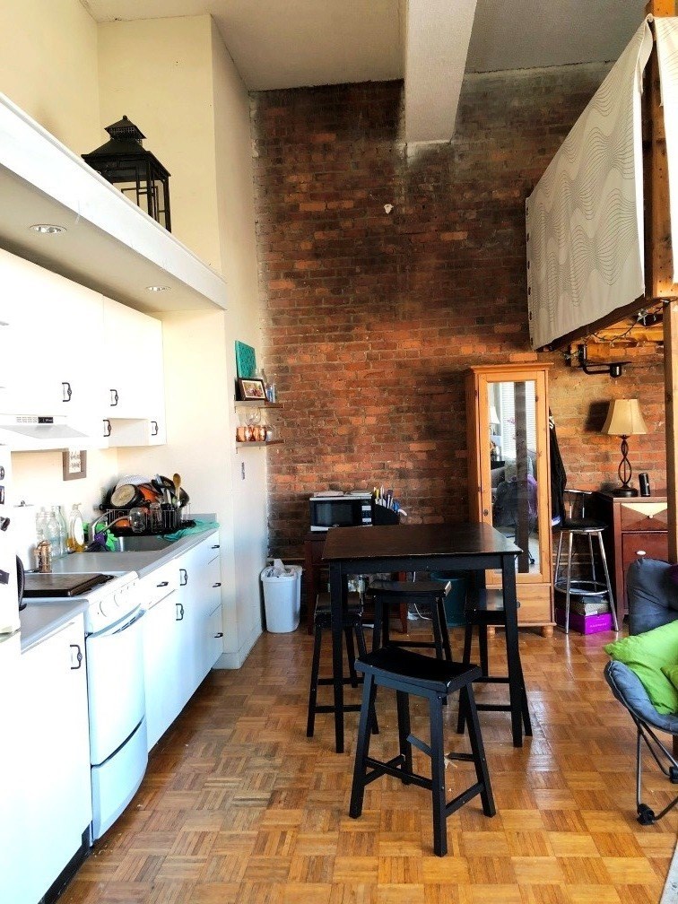 a kitchen and dining room with a brick wall