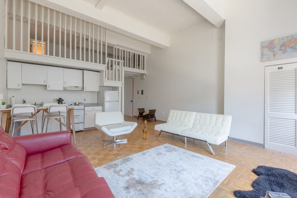 a living room with a couch and a kitchen in the background
