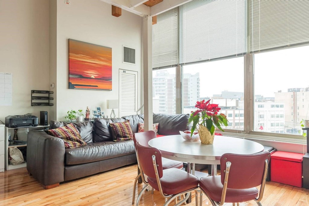 a living room with a large window and a table and chairs