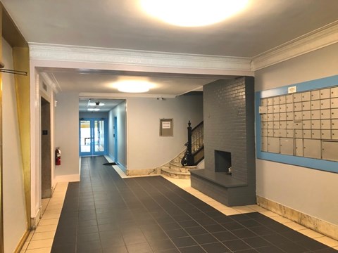 A hallway with a fireplace and a calendar on the wall.