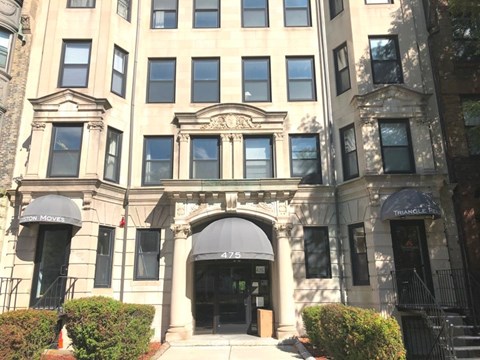 A building with a large front entrance and awnings on the windows.