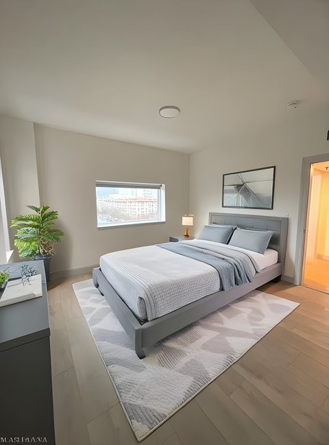 A bedroom with a large bed and a window.