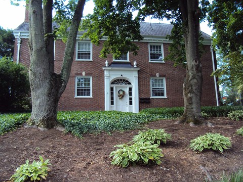 A red brick house with a white door and windows.