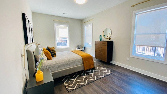 a bedroom with a bed and two windows