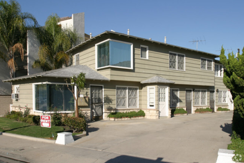 A house with a "For Sale" sign in front of it.