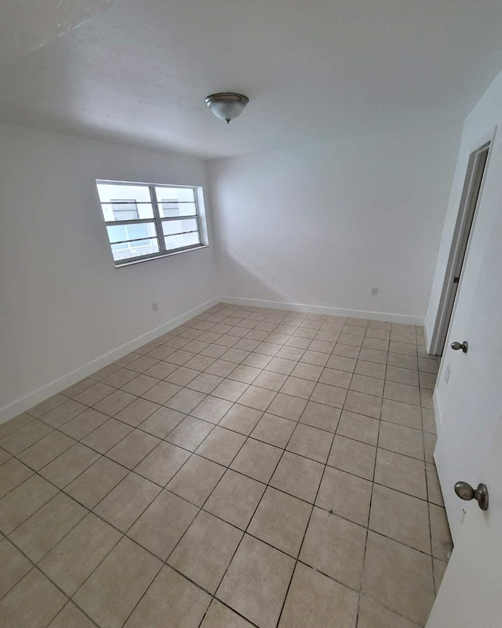 a empty room with a tile floor and a window