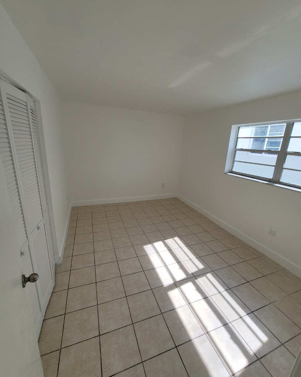 a room with a tiled floor and a window