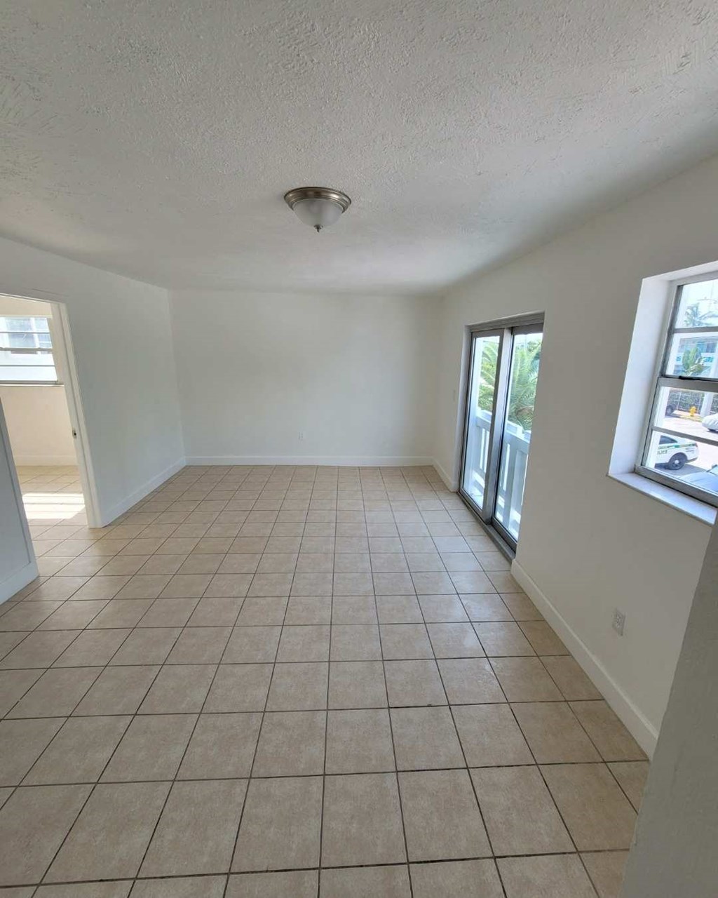an empty living room with a tiled floor