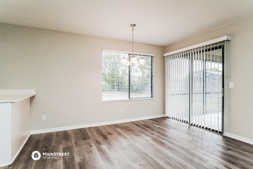 the spacious living room with a large window and wood flooring