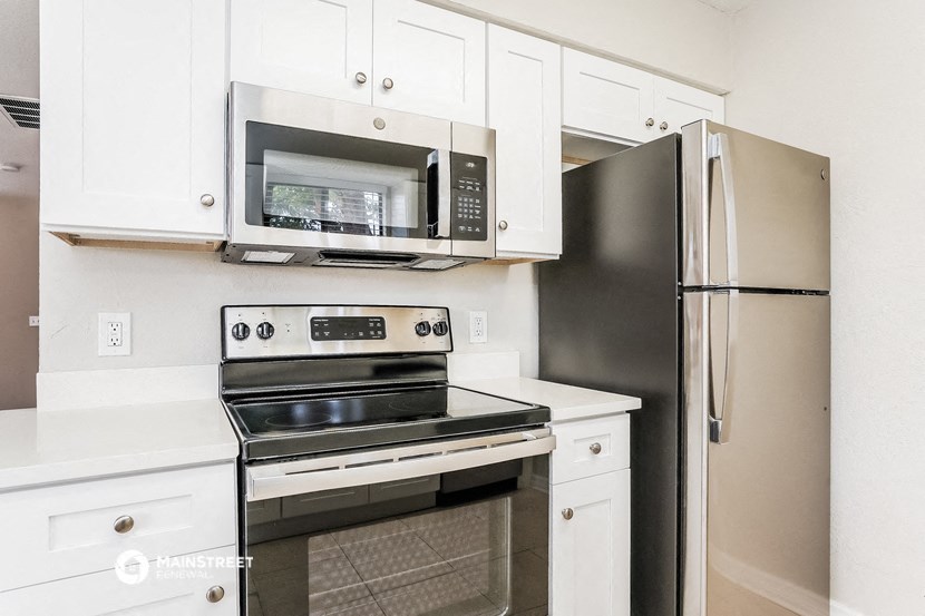 a kitchen with stainless steel appliances and white cabinets