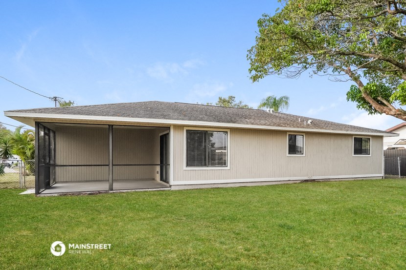 a beige house with a garage and a lawn