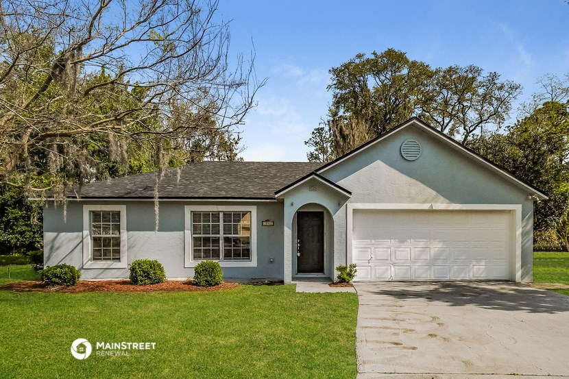 a blue and white house with a lawn and a garage door