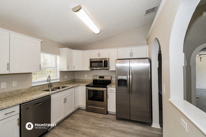 a kitchen with white cabinets and stainless steel appliances