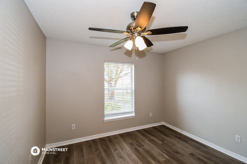 a bedroom with a ceiling fan and a window
