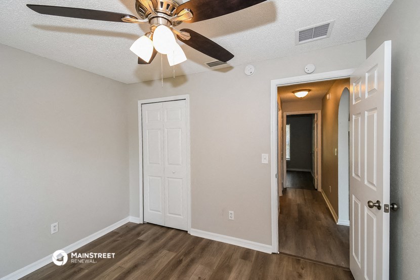 the living room of our two bedroom apartment atrium with a ceiling fan