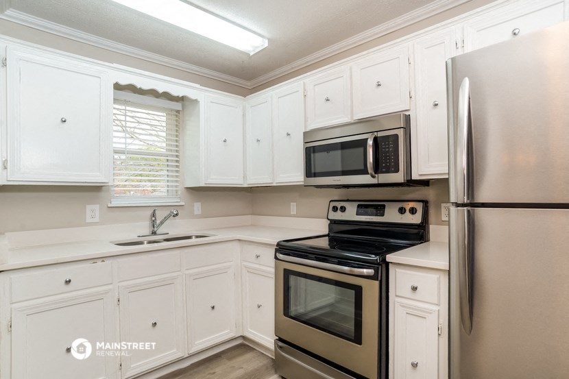 a kitchen with stainless steel appliances and white cabinets