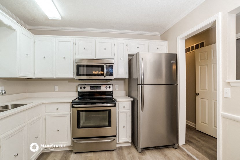 a kitchen with stainless steel appliances and white cabinets