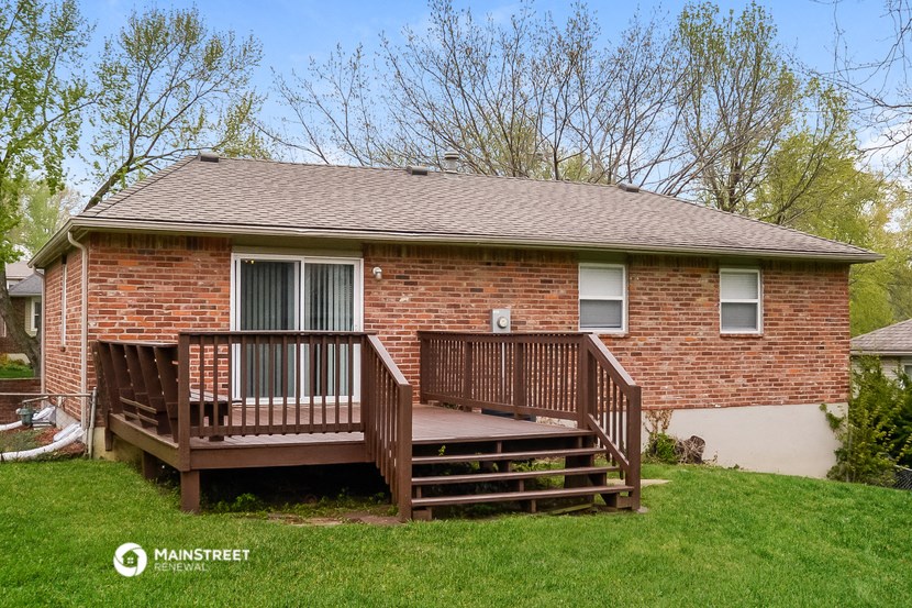 a small brick house with a deck in front of it